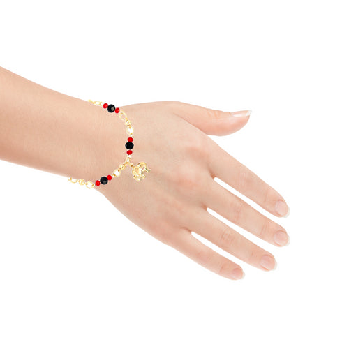 A hand displays the stunning Elephant Charm Bracelet with Black and Red Beads, crafted from 14k gold-filled material. It is beautifully adorned with alternating black and red beads, featuring a small gold elephant charm that dangles elegantly. The adjustable chain provides a perfect fit against the plain white background.